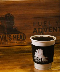 Black coffee in take out cup with Devil's Head Coffee logo on the coffee sleeve